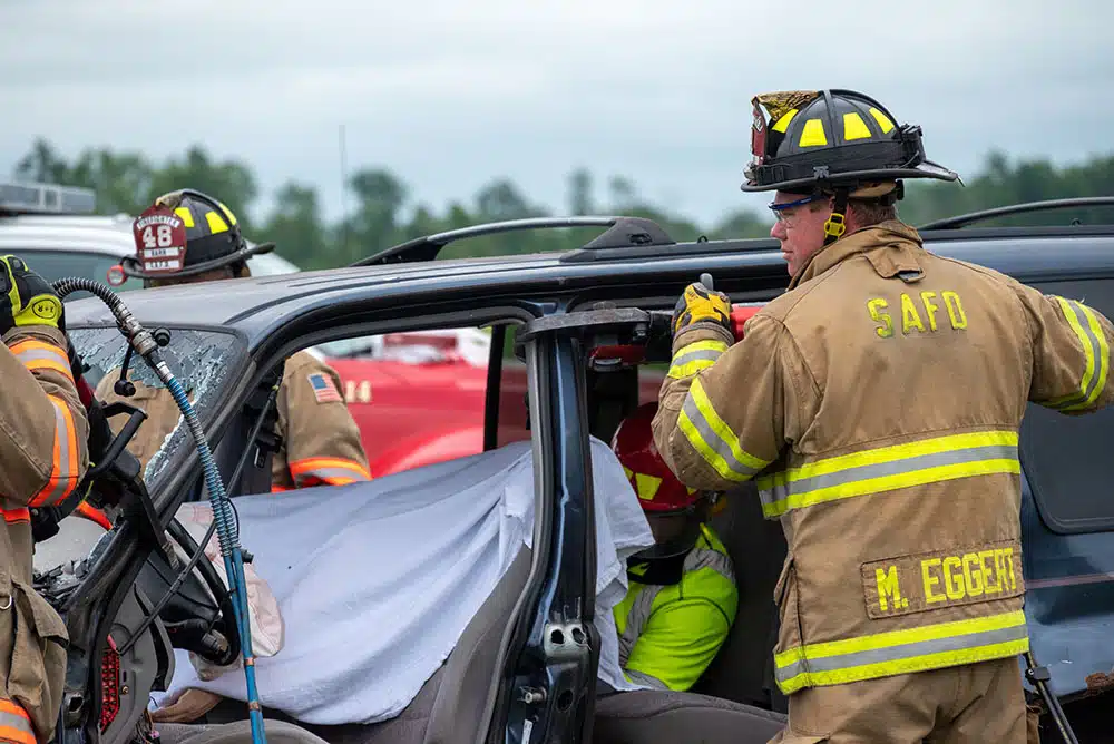 Firefighter helping someone out of their car after a car accident in Jackson, MS
